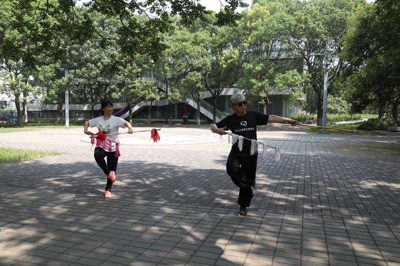 市民在奥林匹克森林公园外的树荫处健身。人民网记者 李乃妍摄